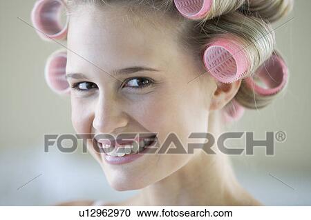 A young woman with her hair in curlers View Large Photo Image Stock Image - A young woman with her hair in curlers. Fotosearch