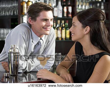 Stock Image - A barman flirting with a customer. Fotosearch