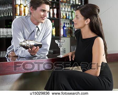 A barman flirting with a customer View Large Photo Image Stock Photograph - A barman flirting with a customer. Fotosearch