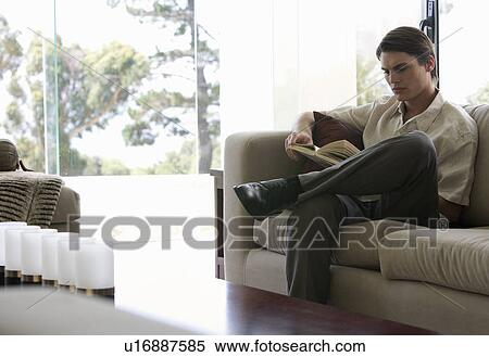 A young man reading a book View Large Photo Image Stock Photography - A young man reading a book. Fotosearch