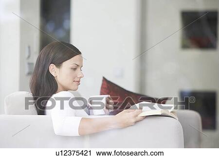 A young woman relaxing with a book View Large Photo Image Stock Image - A young woman relaxing with a book. Fotosearch
