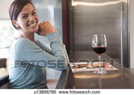 A young woman relaxing with a glass of wine View Large Photo Image Stock Photography - A young woman relaxing with a glass of wine. Fotosearch