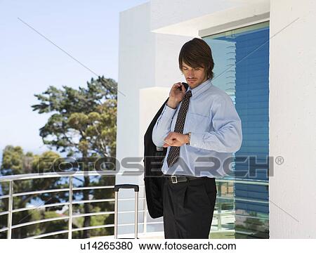 A businessman looking at his watch View Large Photo Image Stock Image - A businessman looking at his watch. Fotosearch