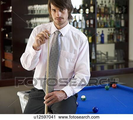 A businessman playing pool in a bar View Large Photo Image Stock Image - A businessman playing pool in a bar. Fotosearch