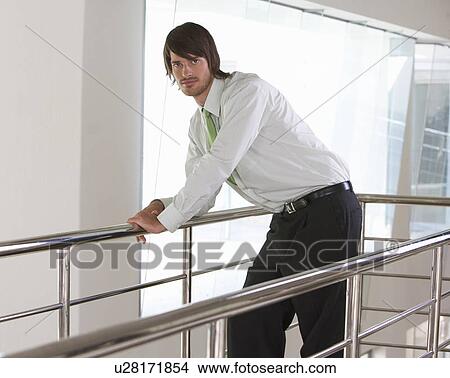 A businessman standing on a balcony View Large Photo Image Picture - A businessman standing on a balcony. Fotosearch