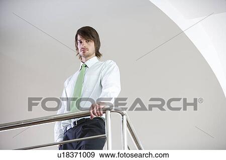 A businessman standing on a balcony View Large Photo Image Stock Photo - A businessman standing on a balcony. Fotosearch