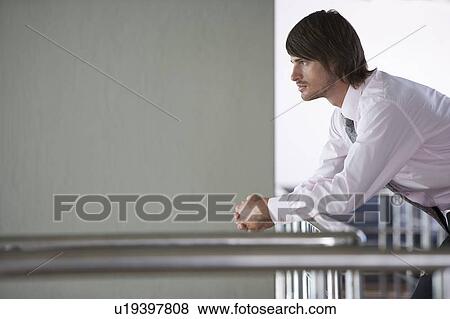 Stock Photo - A businessman standing on a balcony. Fotosearch