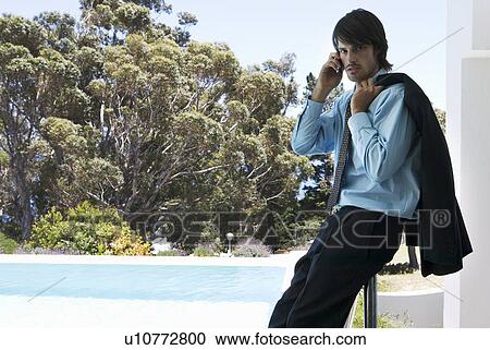 Stock Image - A businessman using a mobile phone. Fotosearch