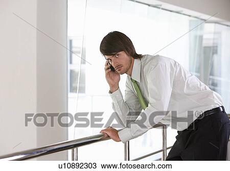 Stock Image - A businessman using a mobile phone. Fotosearch