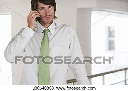 A businessman using a mobile phone View Large Photo Image Stock Photo - A businessman using a mobile phone. Fotosearch