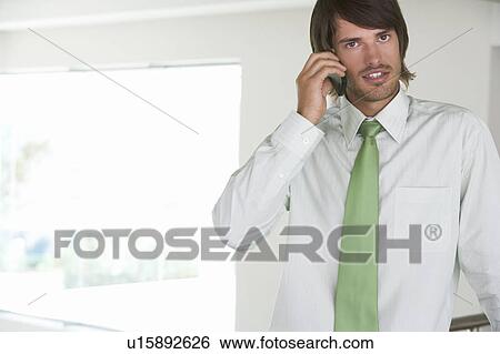 A businessman using a mobile phone View Large Photo Image Stock Photograph - A businessman using a mobile phone. Fotosearch