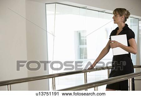 Stock Image - A businesswoman carrying a laptop. Fotosearch