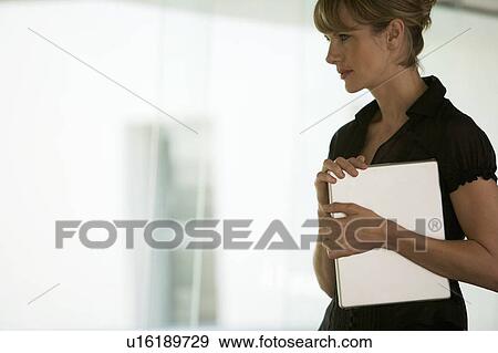 A businesswoman carrying a laptop View Large Photo Image Stock Photo - A businesswoman carrying a laptop. Fotosearch