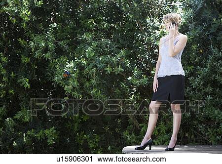 Stock Image - A businesswoman using a mobile phone. Fotosearch