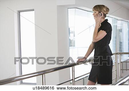 A businesswoman using a mobile phone View Large Photo Image Stock Photograph - A businesswoman using a mobile phone. Fotosearch