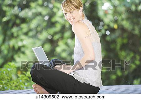 A young woman using a laptop View Large Photo Image Stock Image - A young woman using a laptop. Fotosearch