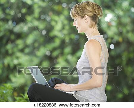 Stock Photograph - A young woman using a laptop. Fotosearch