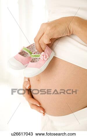 A mother holding a pair of baby shoes View Large Photo Image Stock Image - A mother holding a pair of baby shoes. Fotosearch