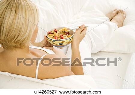 Stock Photo - A pregnant woman eating breakfast. Fotosearch
