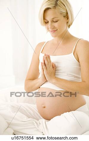 Picture - A pregnant woman practicing yoga. Fotosearch