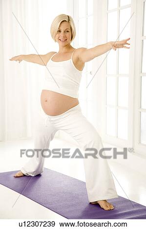 A pregnant woman practicing yoga View Large Photo Image Stock Photo - A pregnant woman practicing yoga. Fotosearch