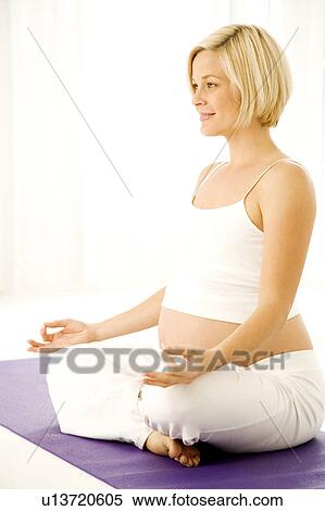 Stock Photography - A pregnant woman practicing yoga. Fotosearch