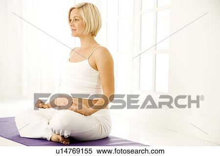 Stock Photography - A pregnant woman practicing yoga. Fotosearch