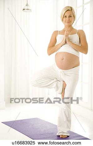 Stock Photography - A pregnant woman practicing yoga. Fotosearch