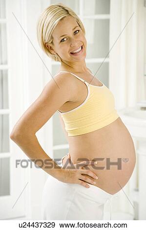 A pregnant woman standing in a bathroom View Large Photo Image Stock Photo - A pregnant woman standing in a bathroom. Fotosearch