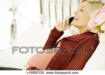 A pregnant woman talking on a telephone View Large Photo Image Stock Photography - A pregnant woman talking on a telephone. Fotosearch