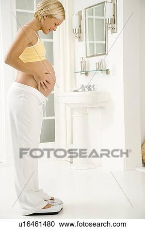 A pregnant woman weighing herself View Large Photo Image Stock Image - A pregnant woman weighing herself. Fotosearch