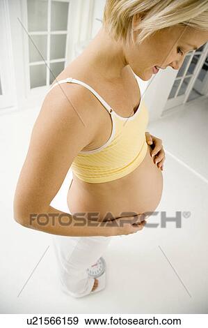A pregnant woman weighing herself View Large Photo Image Stock Photo - A pregnant woman weighing herself. Fotosearch