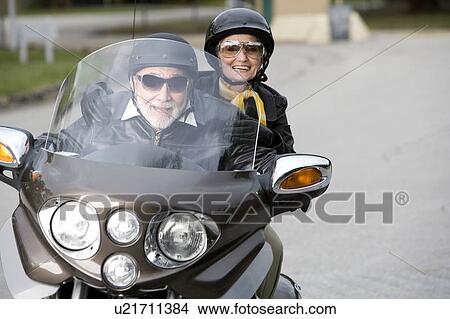 Picture - A senior couple on a motorbike. Fotosearch