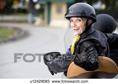 Stock Image - A senior couple on a motorbike. Fotosearch
