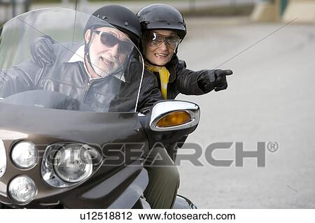 Stock Image - A senior couple on a motorbike. Fotosearch