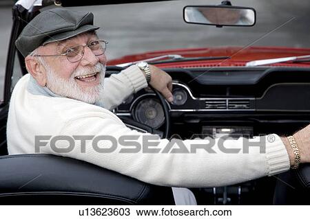 Stock Image - A senior man driving a sports car. Fotosearch