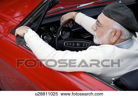 Stock Photography - A senior man driving a sports car. Fotosearch