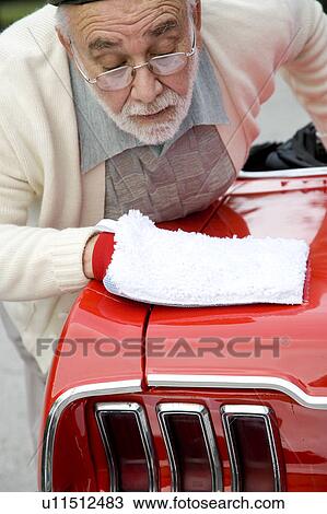 Stock Image - A senior man polishing a sports car. Fotosearch