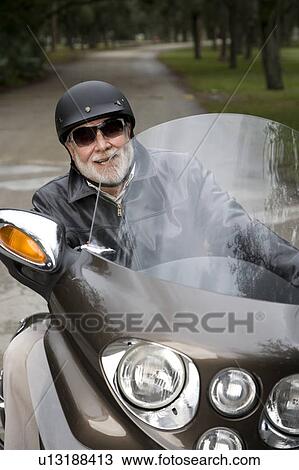 Stock Image - A senior man riding a motorbike. Fotosearch