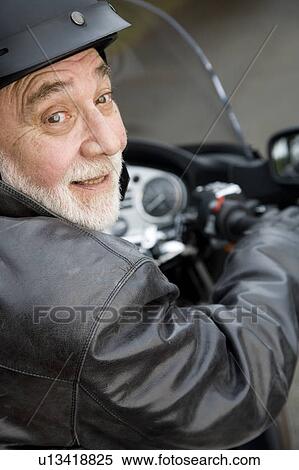 Stock Photography - A senior man riding a motorbike. Fotosearch