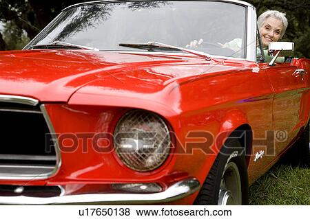 Stock Photo - A senior woman driving a sports car. Fotosearch