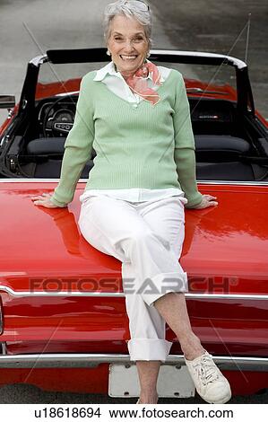 A senior woman sitting on a sports car View Large Photo Image Picture - A senior woman sitting on a sports car. Fotosearch