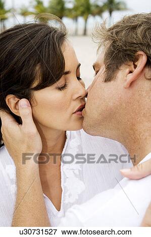 A couple kissing on a beach View Large Photo Image Stock Photo - A couple kissing on a beach. Fotosearch