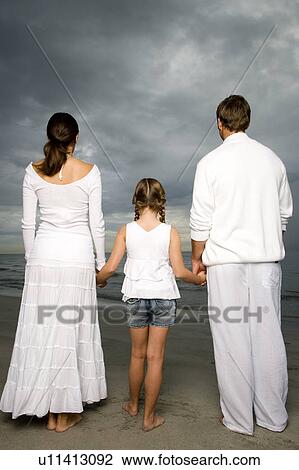 Stock Image - A couple with their daughter on a beach. Fotosearch