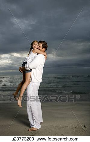 Stock Image - A father and daughter on a beach. Fotosearch