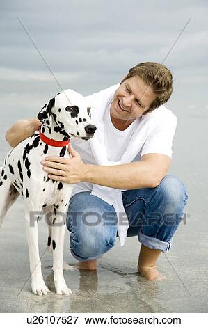 A man with his dog on a beach View Large Photo Image Stock Photo - A man with his dog on a beach. Fotosearch