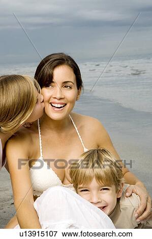 Stock Photo - A mother and her children on a beach. Fotosearch