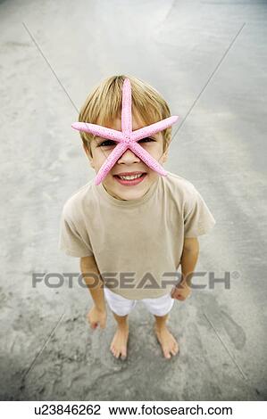 A young boy holding a starfish View Large Photo Image Stock Image - A young boy holding a starfish. Fotosearch