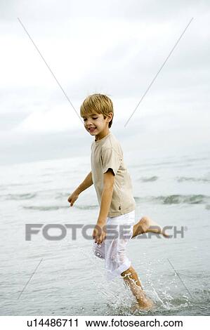 A young boy running on a beach View Large Photo Image Stock Image - A young boy running on a beach. Fotosearch