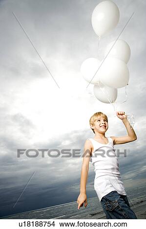 A young boy with a bunch of balloons View Large Photo Image Picture - A young boy with a bunch of balloons. Fotosearch